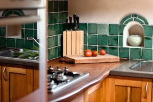 Leela Kitchen with green handmade tiles and wooden chopping boards