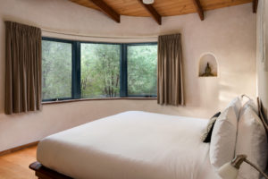 A double bed and large window to the bush