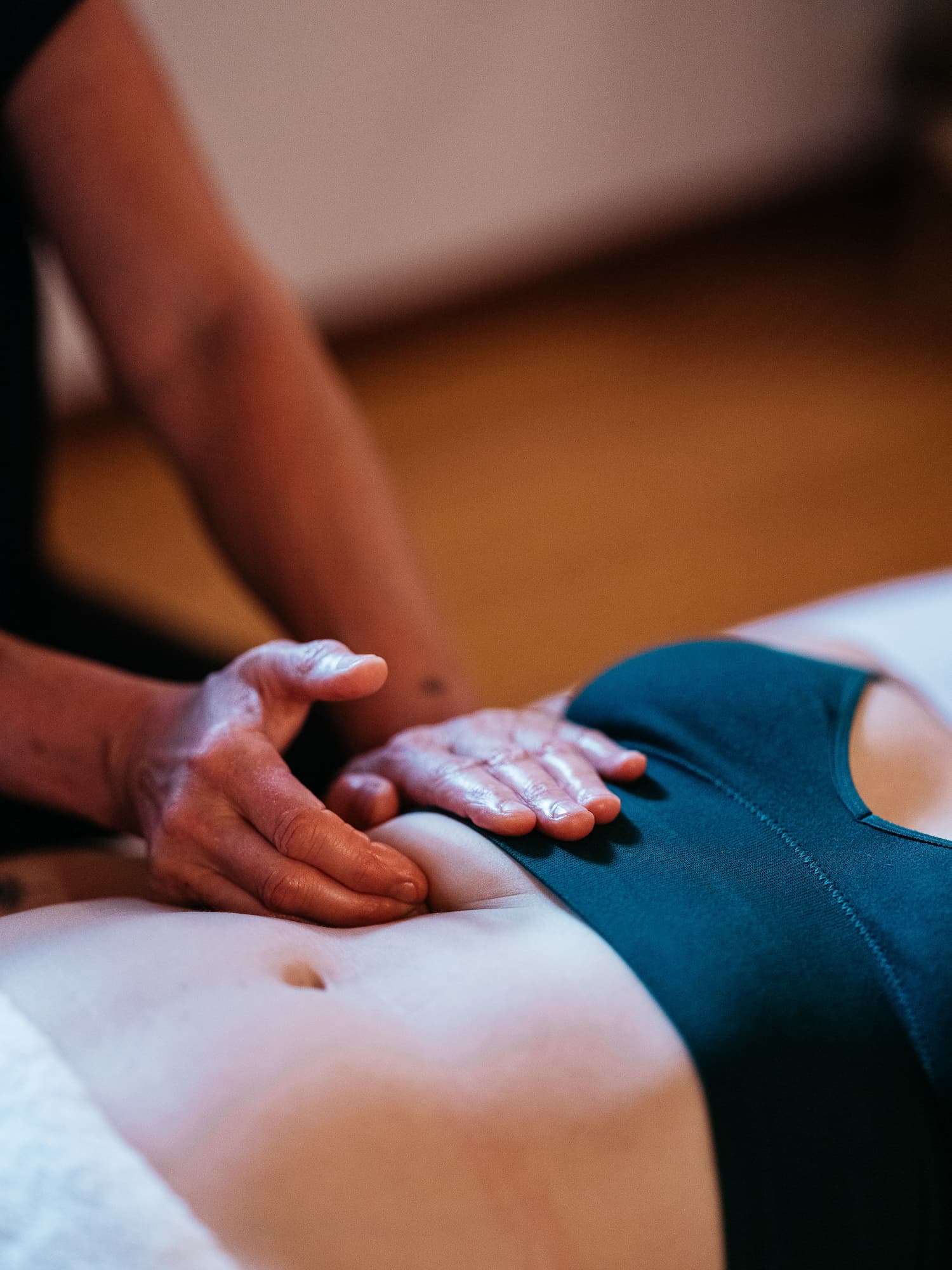 Massage therapist stretching a tatooed man's arm.